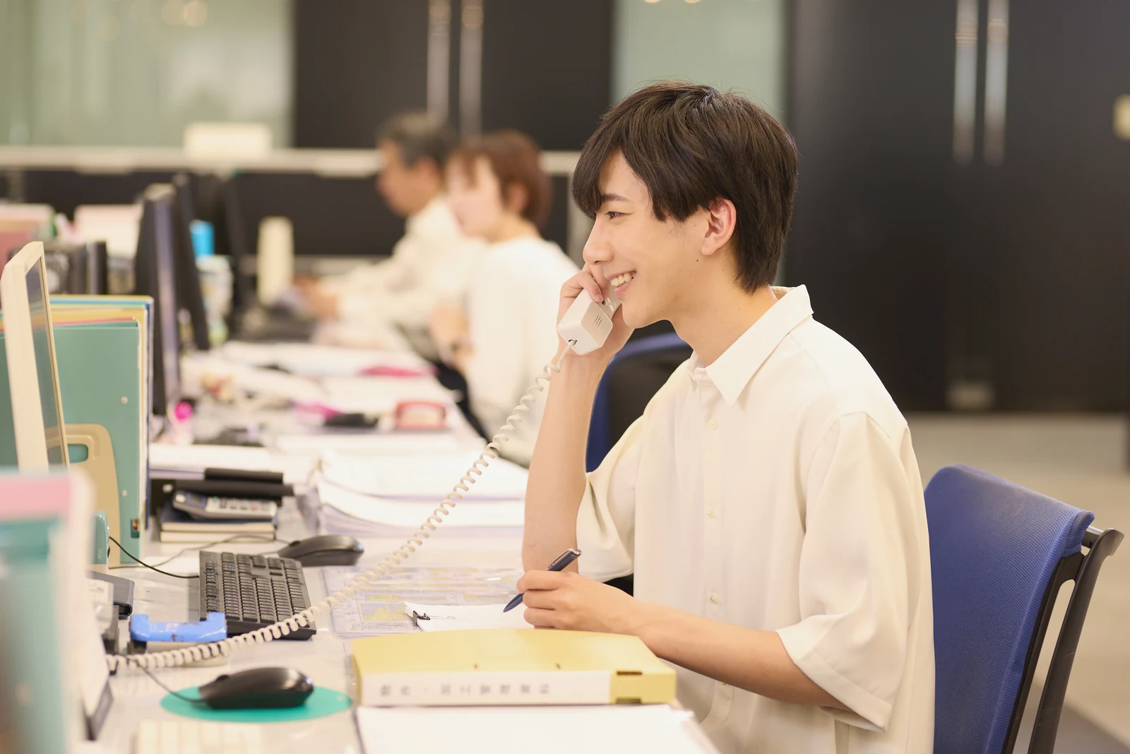 オフィスで電話対応をする社員